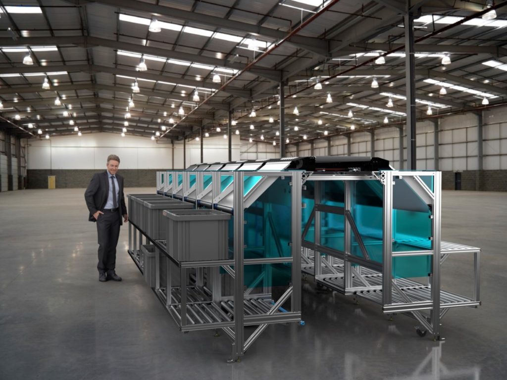 an image of a man in business attire standing beside eSort modules inside a warehouse